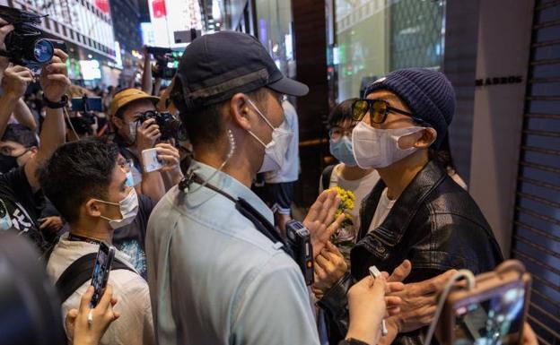 Un hombre se encara con un policía durante una vigilia por las víctimas del covid, este lunes en Hong Kong./JEROME FAVRE