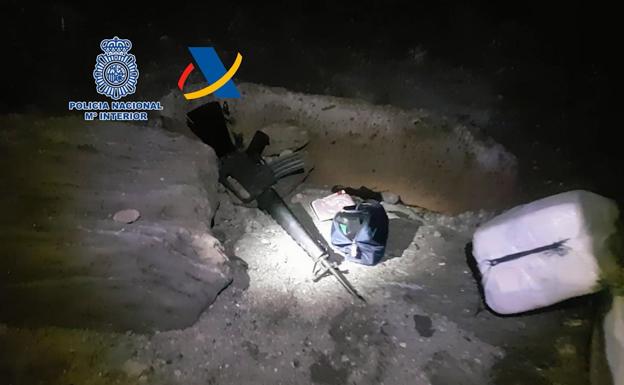 Imagen de un fusil incautado a uno de los miembros de la banda, junto a un fardo de cocaína en la playa de Medio Almud. / POLICÍA NACIONAL