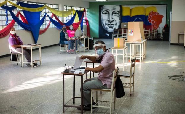 Los responsables de un colegio electoral de Caracas, desocupados por la escasa a asistencia de votantes./AFP