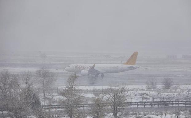 Una avión en el aeropuerto de Barajas, completamente lleno de nieve.