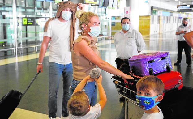 Un grupo de turistas con mascarillas a su llegada al aeropuerto de Gran Canaria. /Juan Carlos Alonso