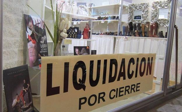 Una cartel de liquidación por cierre en una zapatería. 
