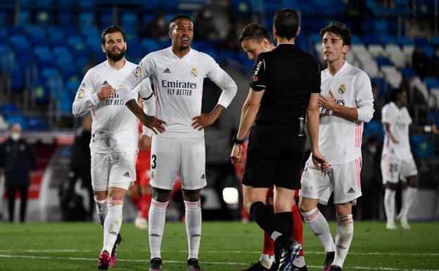 Los jugadores del Real Madrid protestan el penalti señalado por mano de Militao ante el Sevilla. 