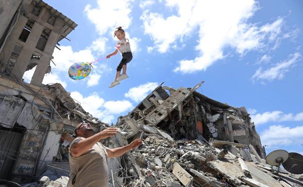 Un palestino juega con una niña junto a los escombros provocados por los bombardeos en Gaza./EP