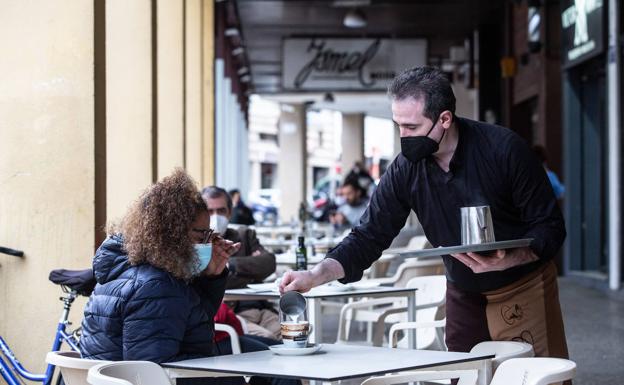 Un camarero sirviendo café en la terraza de un bar en Extremadura. /europa press