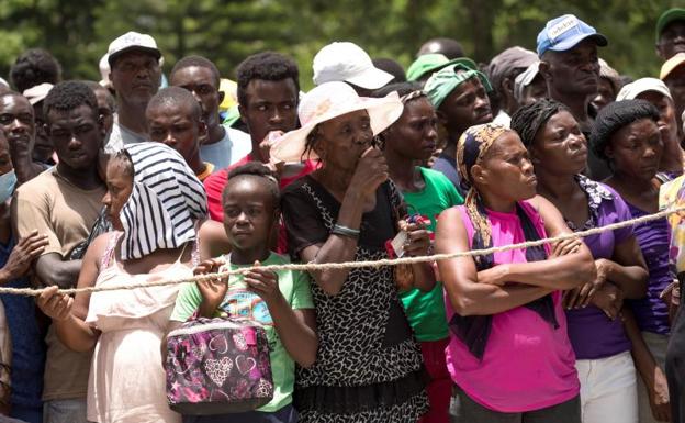 Personas hacen fila para recibir alimentos, en Haití 