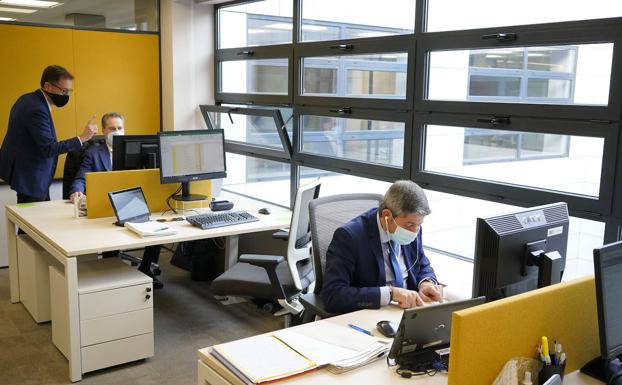 Trabajadores en una oficina de Caixabank en Bilbao./i. Pérez