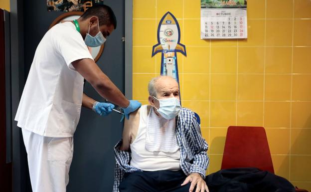 Un anciano recibe la tercera dosis de la vacuna.