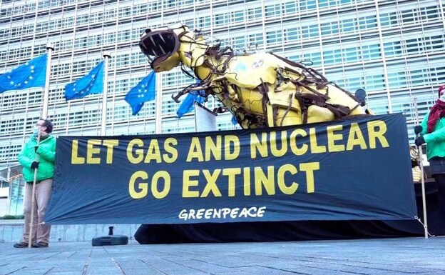 Activistas de Greenpeace instalan un dinosaurio gigante de chatarra frente a la sede de la Comisión Europea, en señal de protesta contra la posible inclusión del gas natural y de la tecnología nuclear en la lista de energías verdes./efe