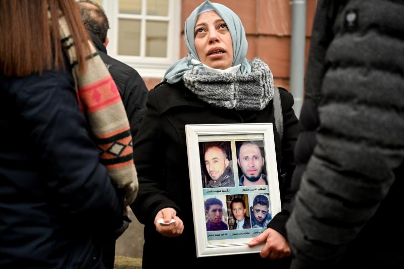 Una refugiada siria muestra fotos de víctimas frente al juzgado de la ciudad de Coblenza. 