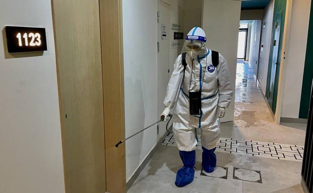 Limpiadores con monos blancos especiales se pasan el día desinfectando los hoteles y las instalaciones de los Juegos