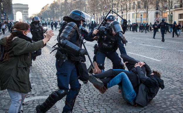 Agentes franceses cargan contra unos jóvenes manifestantes en los Campos Elíseos.