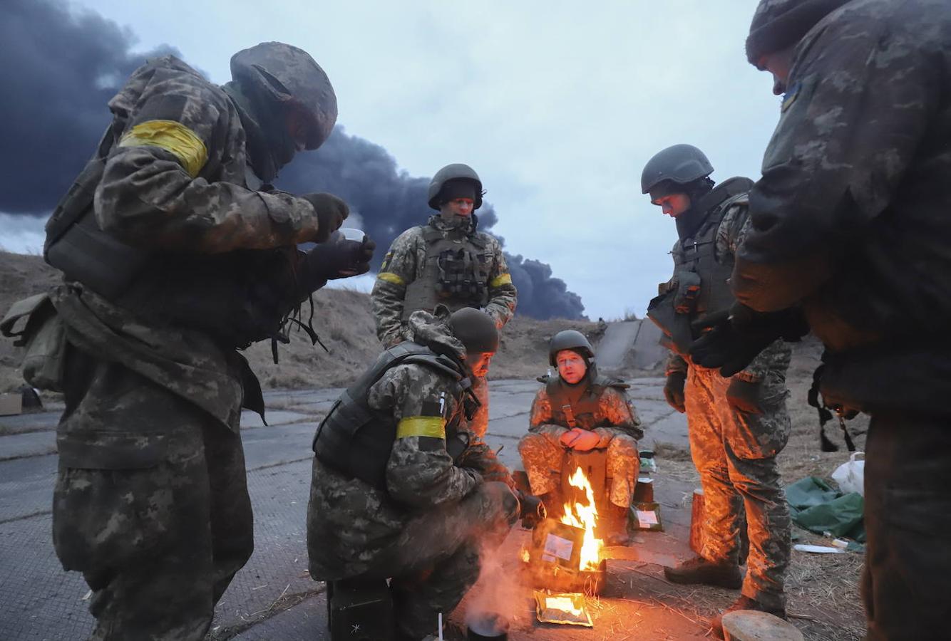 Soldados ucranianos se calientan con una hoguera cerca de Kiev