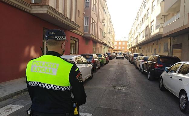 Un agente de la Policía Local vigila la calle Rafael Hervás de Sueca, lugar del crimen./J. A. Marrahí