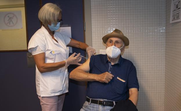 Archive image of a health worker revaccinating an older man against the flu and covid.  / JUAN CARLOS ALONSO