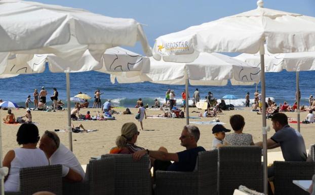 Turistas al sol y en terrazas en una playa de Maspalomas (Gran Canaria)./Efe