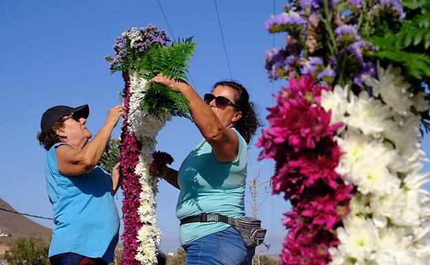 Dos mujeres enraman las cruces de Tesjuate. /javier melián / acfi press