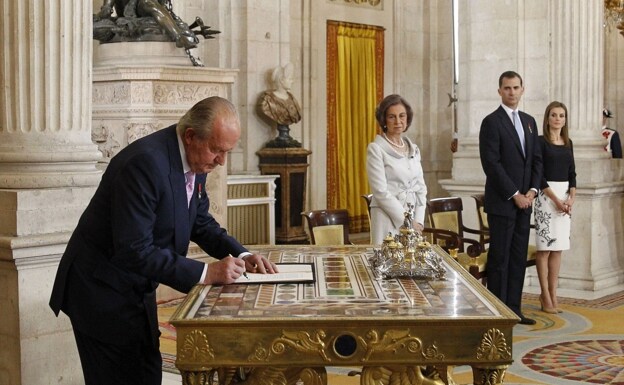 El Rey Juan Carlos I sanciona la ley orgánica por la que se hace efectiva su abdicación del trono español, en presencia de la Reina Sofía y los Príncipes de Asturias, en una ceremonia celebrada en el Salón de Columnas del Palacio Real, el 18 de junio de 2014. /EFE/Alberto Martin