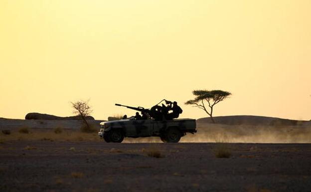 Los soldados del Frente Polisario conducen una camioneta montada con un arma antiaérea durante la puesta de sol en Bir Lahlou./REUTERS