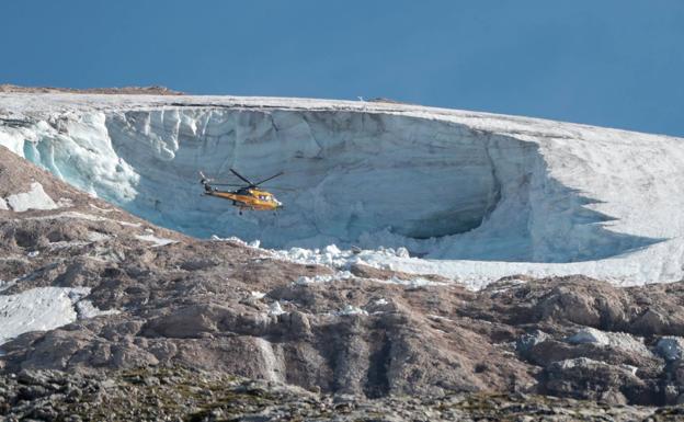 Un helicóptero policial sobrevuela el glaciar Marmolada tras el accidente. /Afp