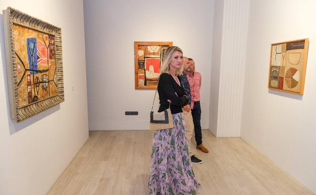 Visitantes a la exposición inaugural, junto a tres obras de Millares. 