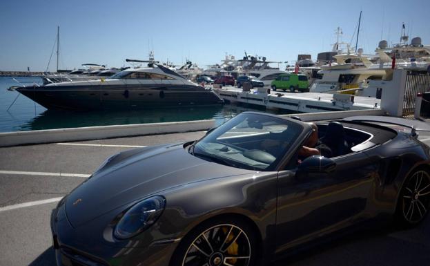 Un hombre conduce un vehículo de alta gama en Puerto Banús, la zona de mayor lujo en Marbella. /afp