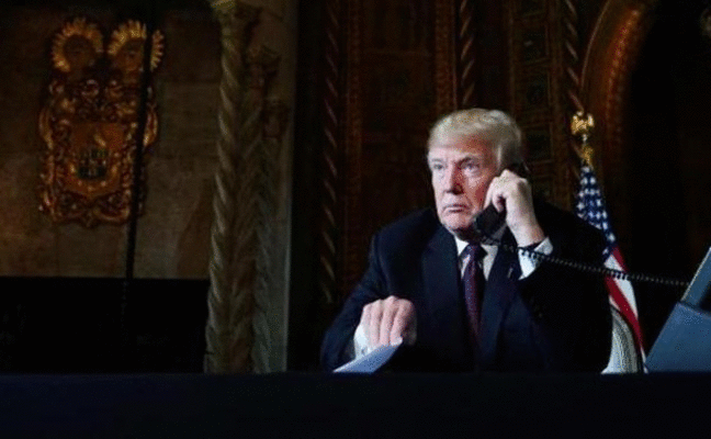 El expresidente Donald Trump habla por teléfono desde su despacho en la mansión de Florida/afp