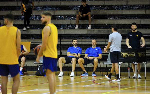Los jugadores del Club Baloncesto Gran Canaria Jovan Kljajic y Oliver Stevic -derecha- observan sentados el entrenamiento realizado en Tafira este miércoles. /cober